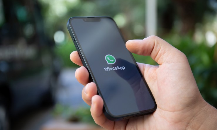 Uno smarphone in mano a una persona con la chat di whatsapp aperta