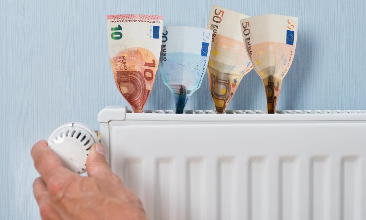 Termostato di un termosifone con delle banconote di euro incastrate