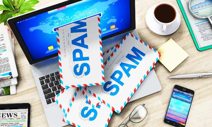 Computer con delle lettere che fuoriesocno dallos chermo e che rappresentano lo SPAM