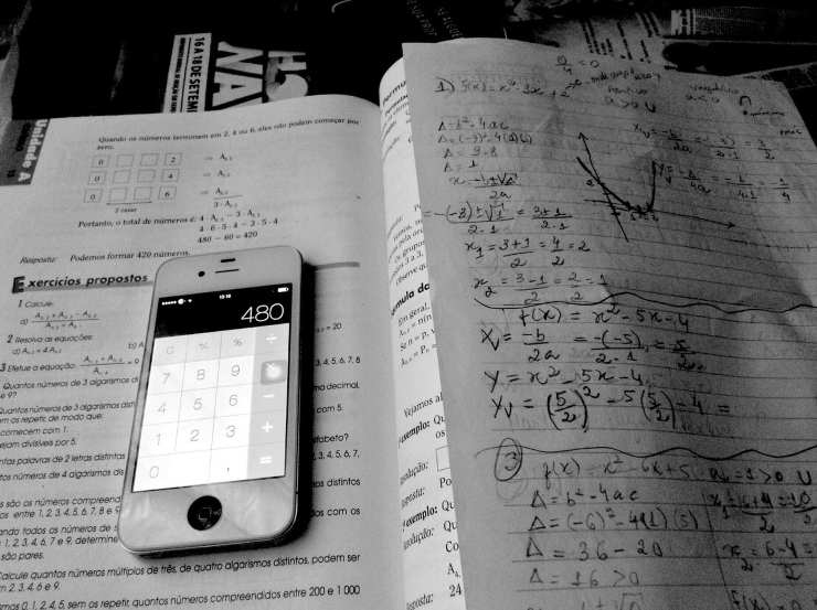 Un cellulare ed un libro con formule matematiche (Pixabay)