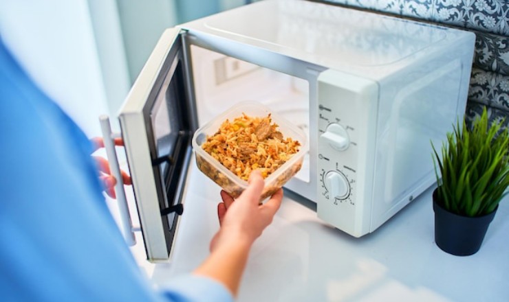 Una donna inserisce il cibo nel microonde