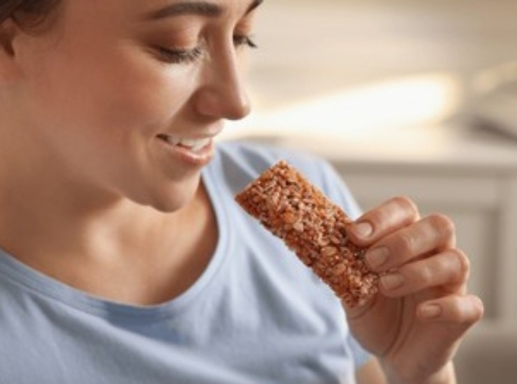 Una giovane donna mangia uno snack