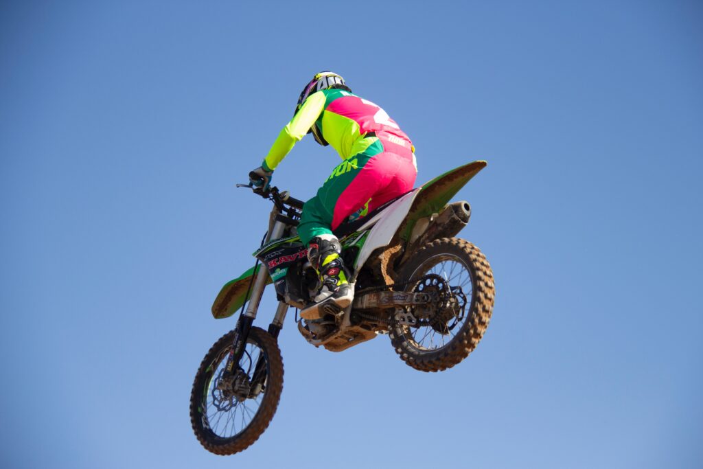 salto acrobatico moto sportiva su sfondo azzurro cielo