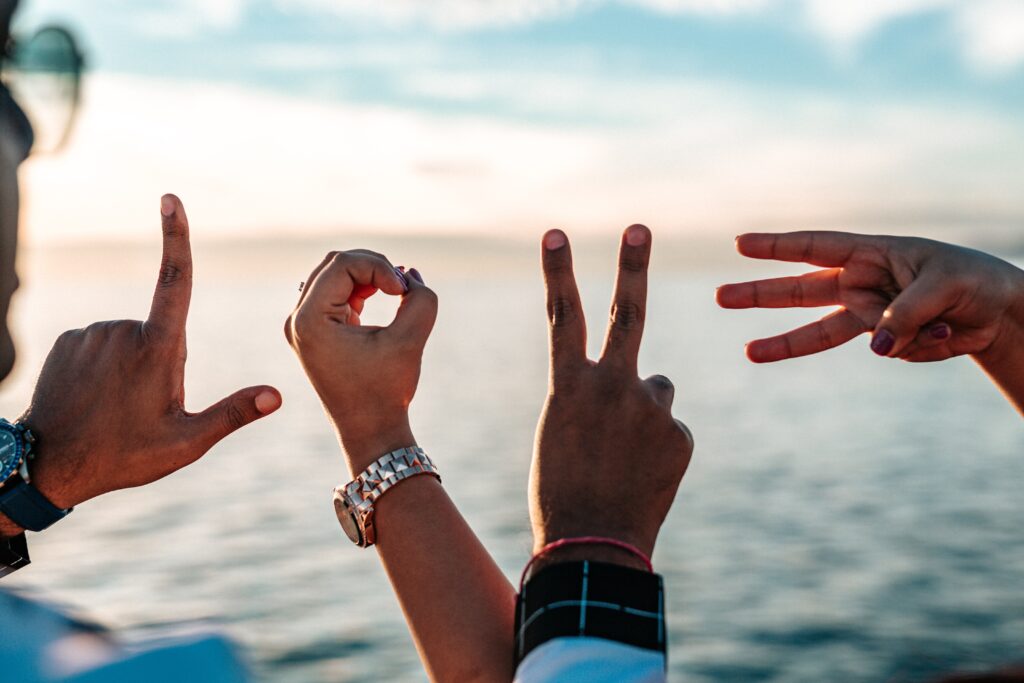 mani formano la scritta LOVE con il mare come sfondo