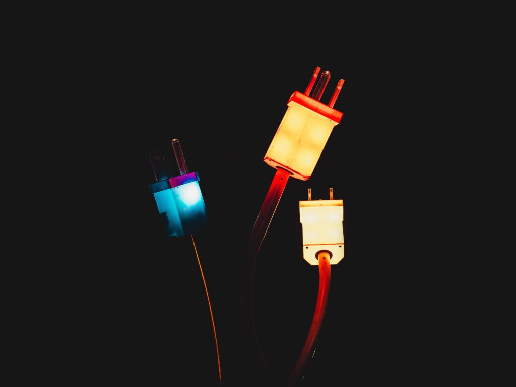 tre spine elettrice fluorescenti su sfondo nero per rappresentare la termoelettricità