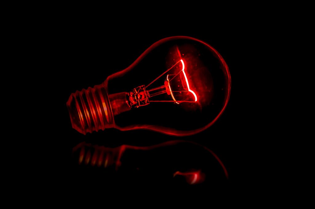 lampadina elettrica rossa su sfondo nero