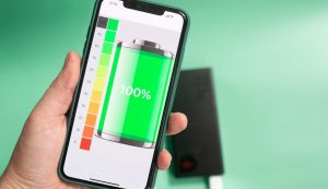 Persona con smartphone in mano con batteria al 100%