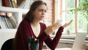 ragazza arrabbiata guarda il telefono