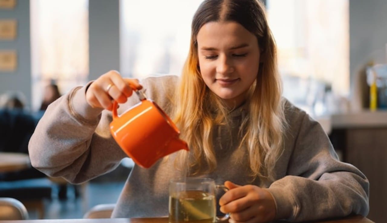 Una giovane donna si versa del tè